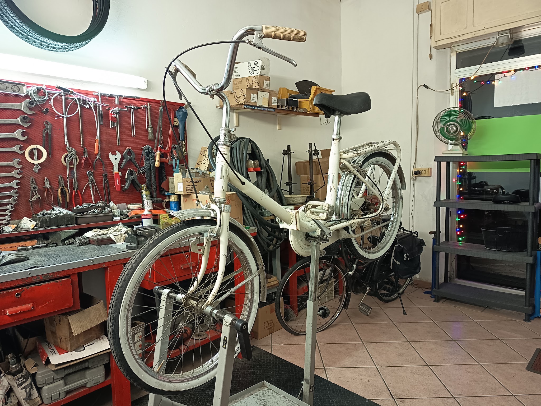 Bicicletta sul cavalletto accanto al banco attrezzi